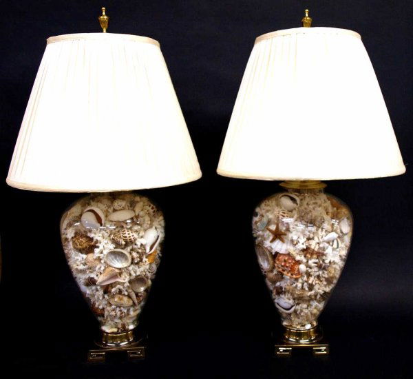 PAIR CUSTOM MADE SEA SHELL FILLED TABLE LAMPS: (pair) Custom sea shell filled table lamps, the urn form glass bodies filled with a variety of shells, coral, starfish, raised on brass feet, , 36"h, 17"d; 34lbs total