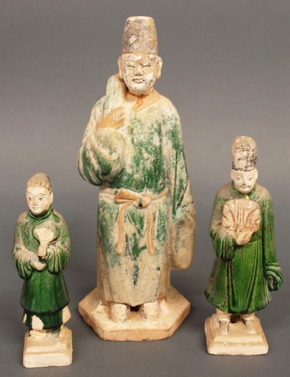 (2) CHINESE MING POTTERY BURIAL / TOMB FIGURES: (lot of 3) Chinese pottery burial/tomb figures, Ming Dynasty, (2) in deep green lead glazed robes each holding a fan, raised on stepped square foot, the larger 8.5"h, 3.5"w; (1) larger, figure of a ma