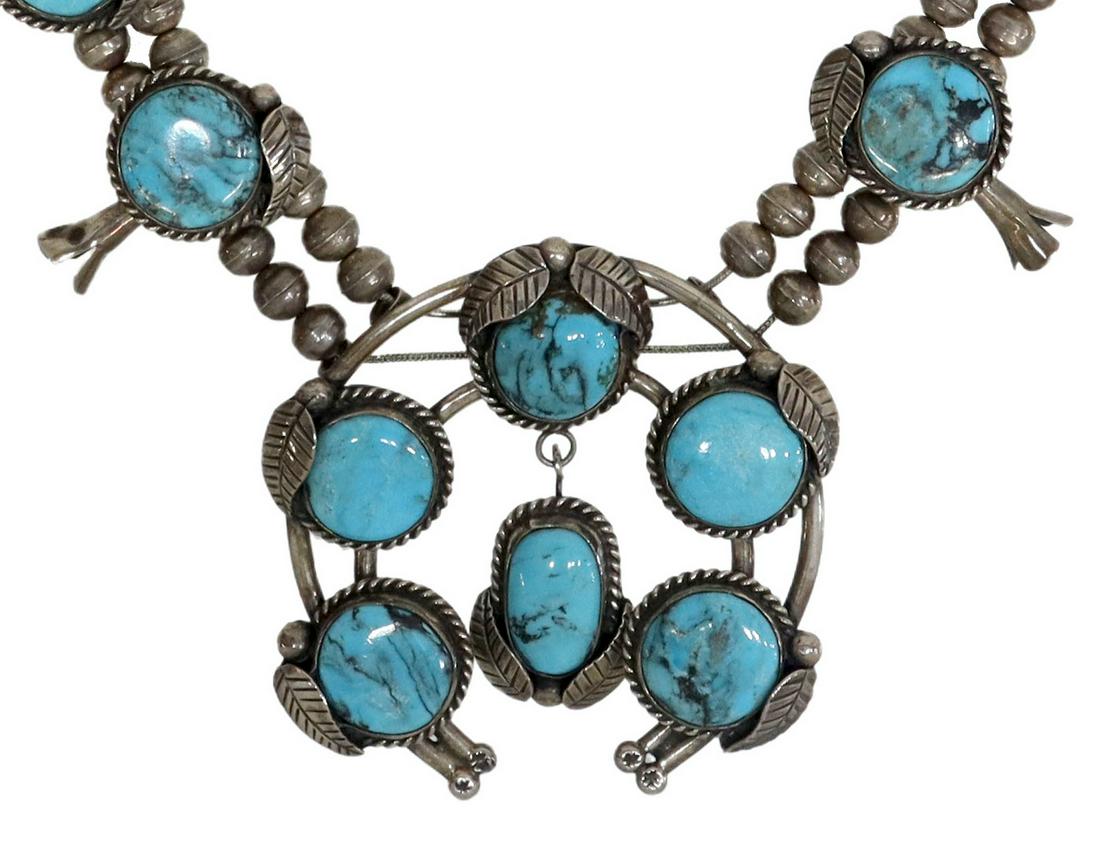 NATIVE AMERICAN TURQUOISE SQUASH BLOSSOM NECKLACE: Native American silver (content unknown) and turquoise squash blossom necklace, likely Navajo, featuring ten round turquoise-set blossoms, central naja pendant and drop set with six stones all bezel s