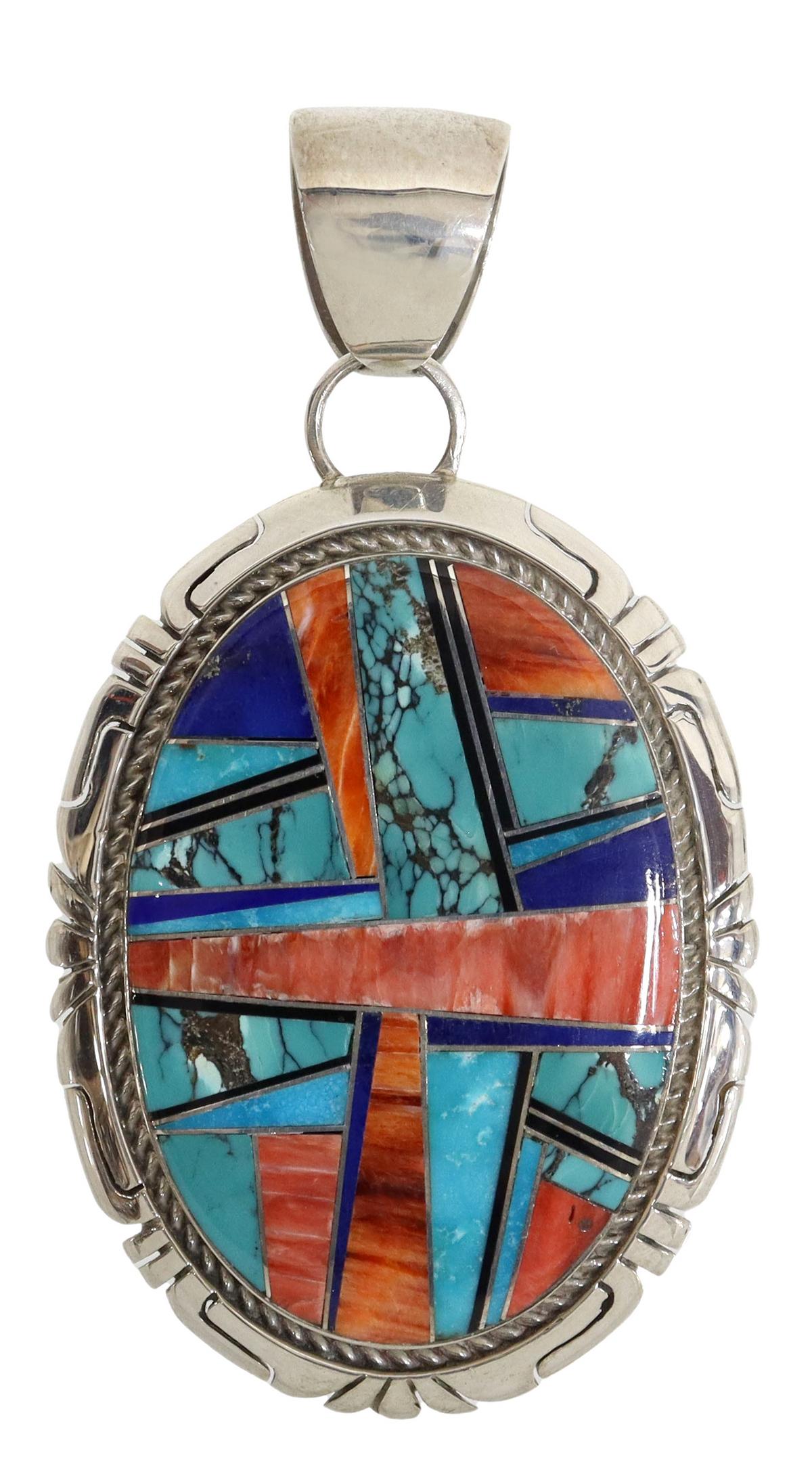 DELVIN JOHN NAVAJO STERLING SILVER INLAID PENDANT: Native American sterling silver pendant, signed Delvin John (John Delvin, Navajo, 20thc.), large oval form with worked border, centering inlays of spiny oyster, lapis, turquoise and jet, wide bail, fu
