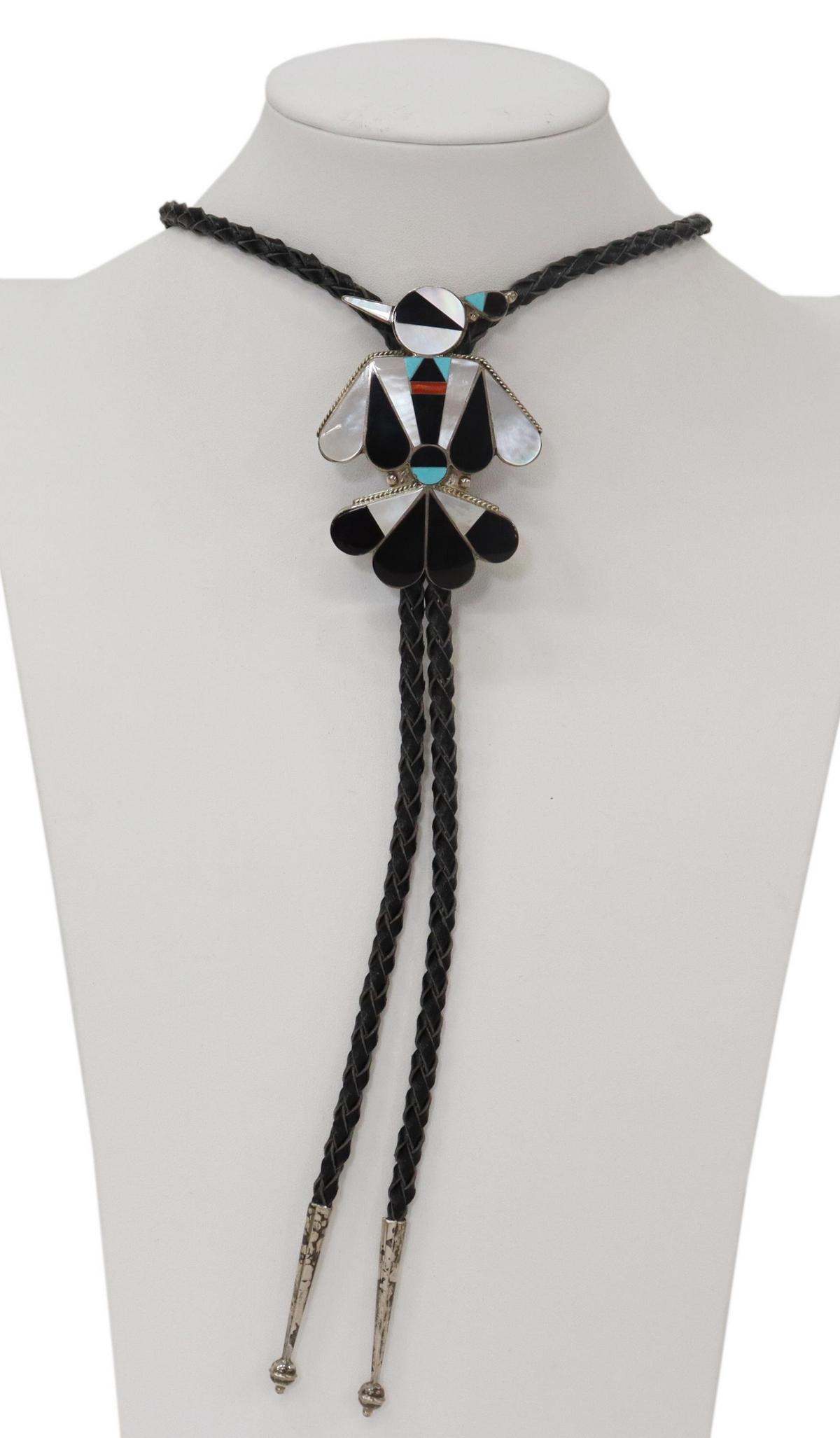 TERRY DISHTA ZUNI STERLING THUNDERBIRD BOLO TIE: Native American sterling silver bolo tie, signed T. Dishta (Terry Dishta, Zuni, New Mexico, 20thc.) thunderbird inlaid with mother of pearl, red coral, jet, and turquoise, silver bolo tips, on a braid