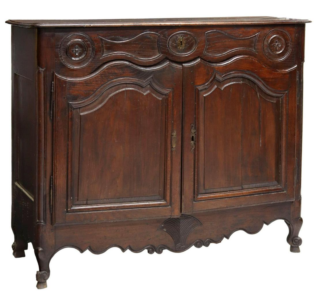 FRENCH LOUIS XV STYLE OAK LIFT-TOP SIDEBOARD: French Provincial Louis XV style oak lift-top sideboard, 19th c., a foliate and geometric carved frieze, over two doors, scalloped apron, rising on cabriole legs, ending in whorl feet, approx 43.25"h,