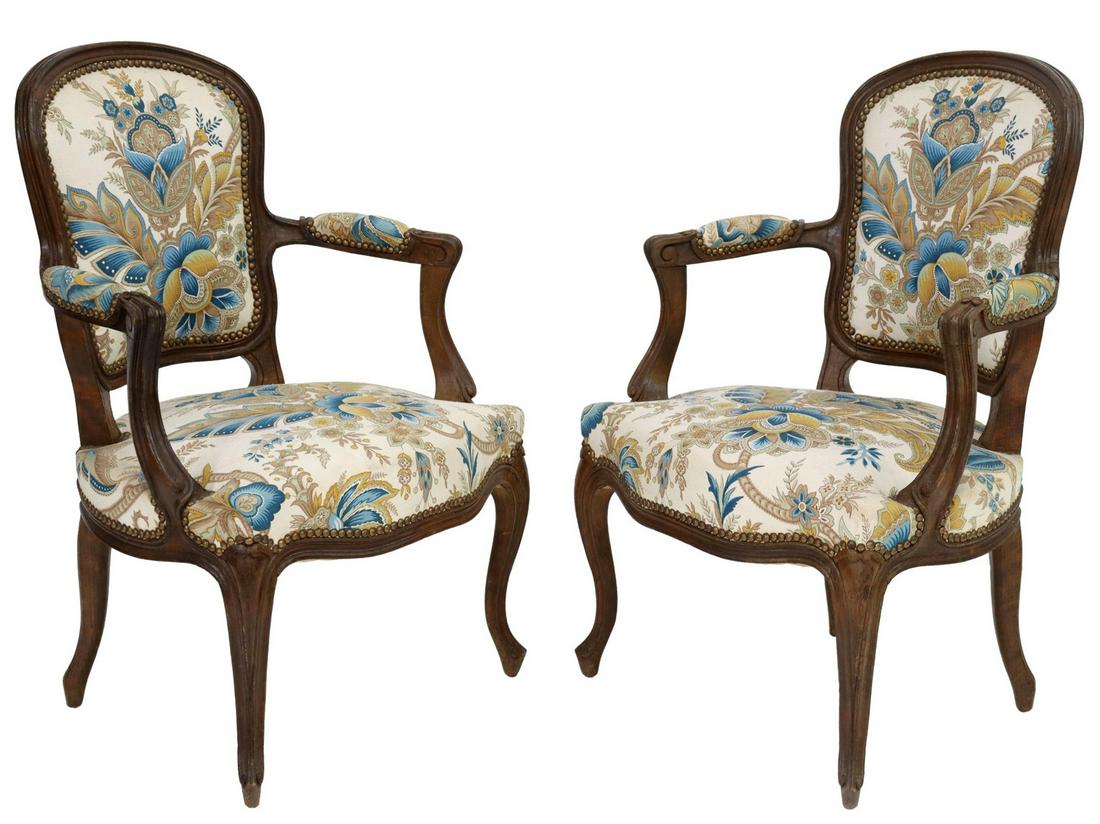 (2) FRENCH LOUIS XV STYLE UPHOLSTERED FAUTEUILS: (pair) French Louis XV style armchairs, early 20th c., padded back, arms, and seat, in floral patterned upholstery, tack trim, rising on cabriole legs, ending in whorl feet, approx 33.75"h, 23.25"w, 1