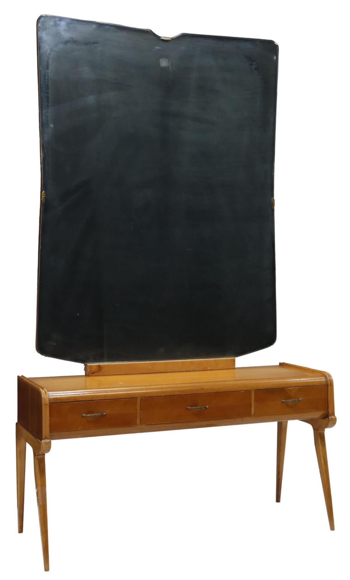 ITALIAN MID-CENTURY MODERN MIRRORED VANITY TABLE: Italian mid-century modern fruitwood dressing table and mirror, c.1950s, frameless beveled mirror plate, over waterfall-front table, three drawers in matched veneers, rising on tapered legs, approx 67