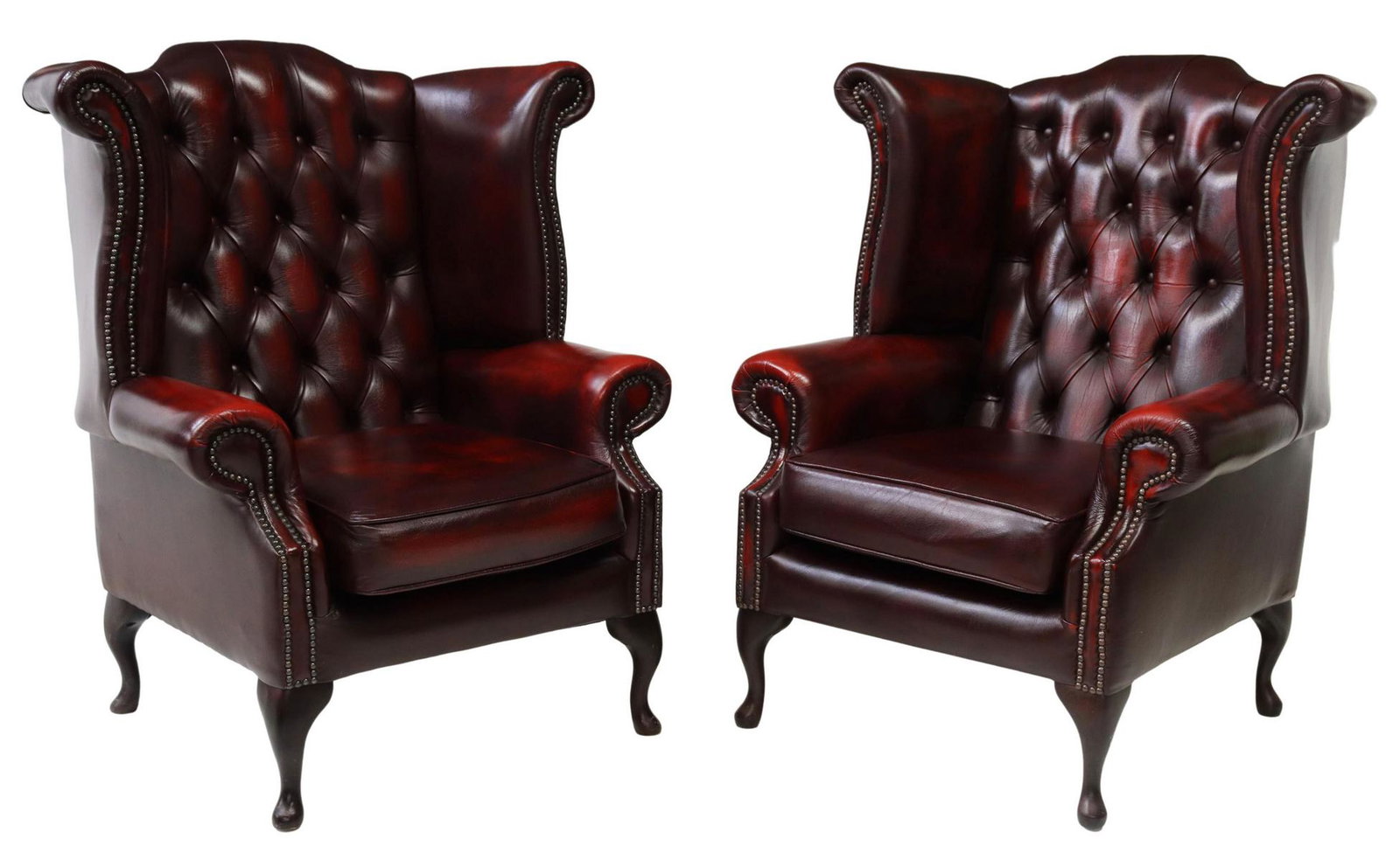 (2) QUEEN ANNE STYLE LEATHER WINGBACK ARMCHAIRS: (pair) English Queen Anne style wingback armchairs, late 20th c., oxblood leather upholstery with button-tufted back, bolster wings and arms, nail head trim, removable cushion, rising on mahogany fini