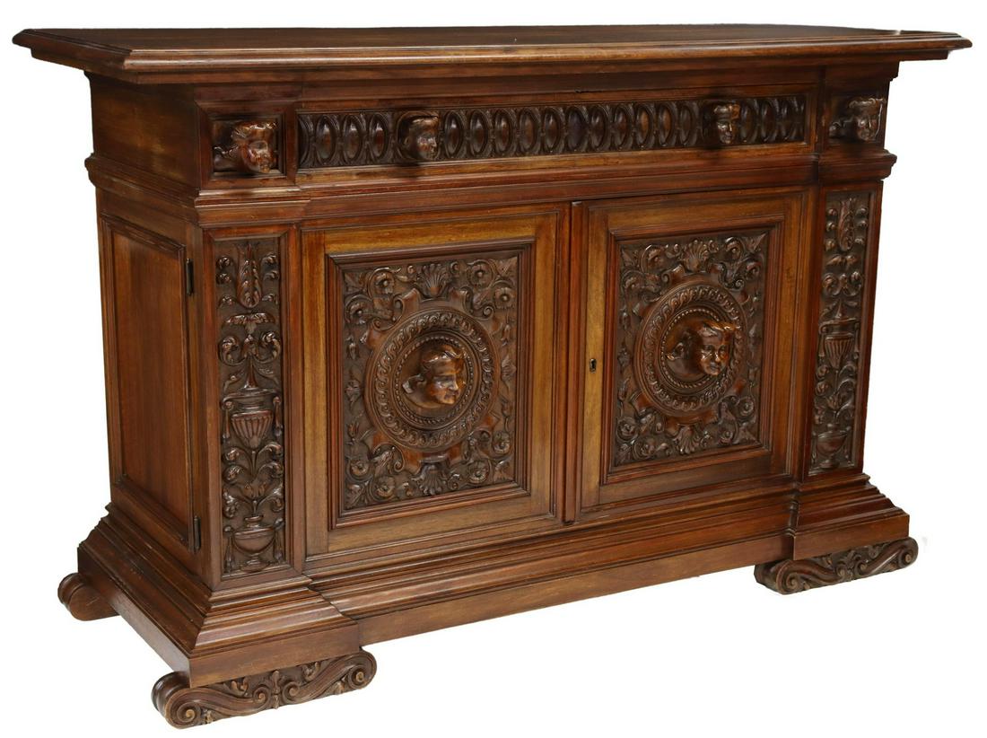 ITALIAN RENAISSANCE REVIVAL CARVED WALNUT COMMODE: Italian Renaissance Revival walnut chest of drawers, Carlo Puccini, early 20th c., richly carved throughout with large figural masks, cartouche, foliated urn and running ring motifs, fitted with recta