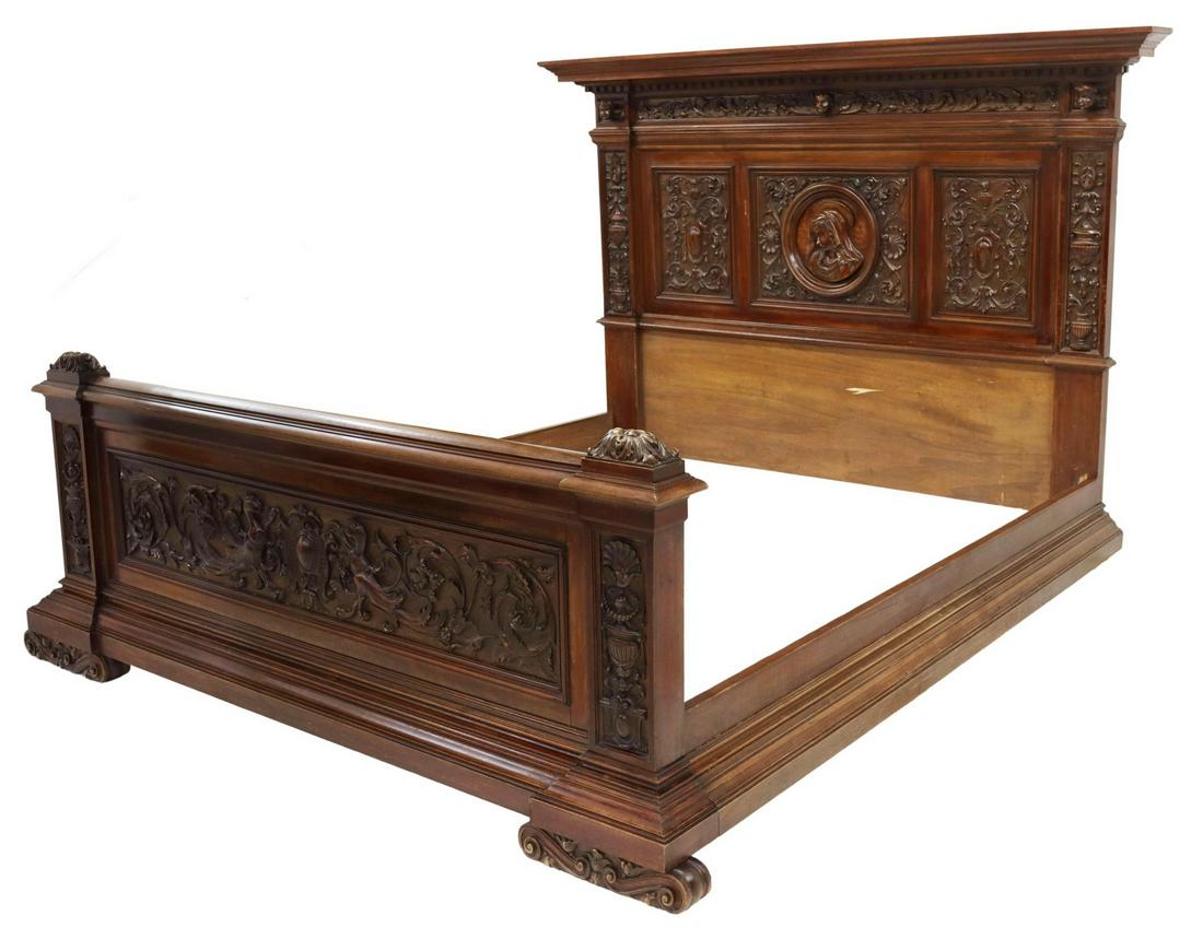 ITALIAN RENAISSANCE REVIVAL CARVED WALNUT BED: Italian Renaissance Revival walnut bed, Carlo Puccini, early 20th c., cornice with dentil molding, frieze with three projecting putti masks, paneled headboard with the Virgin Mary in relief, footboard