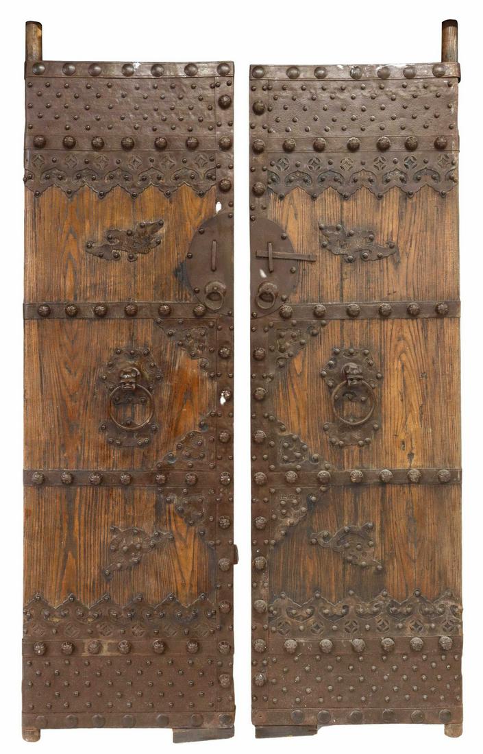 (2) ARCHITECTURAL CHINESE IRON-MOUNTED ELM DOORS: (lot of 2) Architectural Chinese elm doors/ gates, 19th c., iron mounts with raised bosses, foo lion mask and ring pulls, circular lockplate with incised birds, characters, each door: approx 91"h, 27"