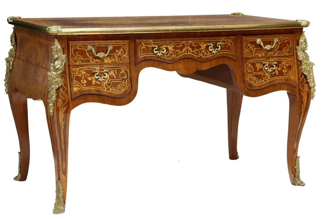 LOUIS XV STYLE METAL-MOUNTED BUREAU PLAT: Louis XV style writing desk, 20th c., accented with floral and foliate marquetry, gilt metal mounts, five drawers, rising on cabriole legs with satyr mounts, ending in paw feet, separation at side pan