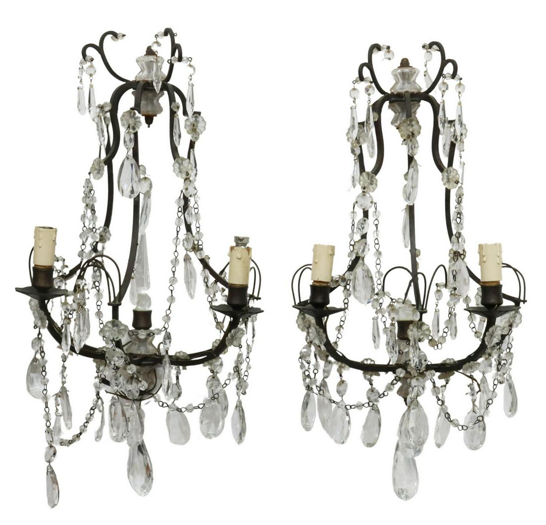 (2) ITALIAN IRON & CRYSTAL PRISM 2-LT WALL SCONCES: (pair) Italian wrought iron and crystal sconces, 20th c., having curving metal frame, hung with garlands and four tiers of prism drops, issuing two arms, ending in floral bobeches and faux candles, ac