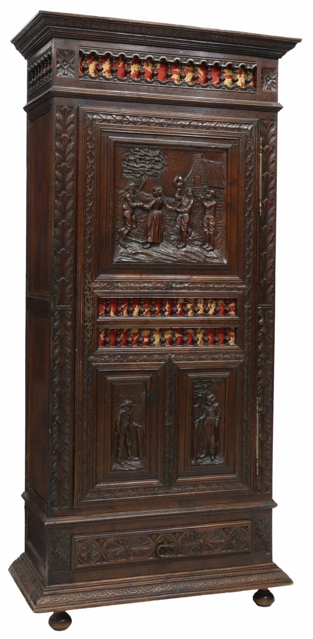 FRENCH BRETON CARVED OAK BONNETIERE: French carved oak bonnetiere, Brittany, late 19th c., molded cornice above a spindled gallery, single door carved with figural scene in relief, lower exterior drawer, rising on bun feet, approx 79"h, 