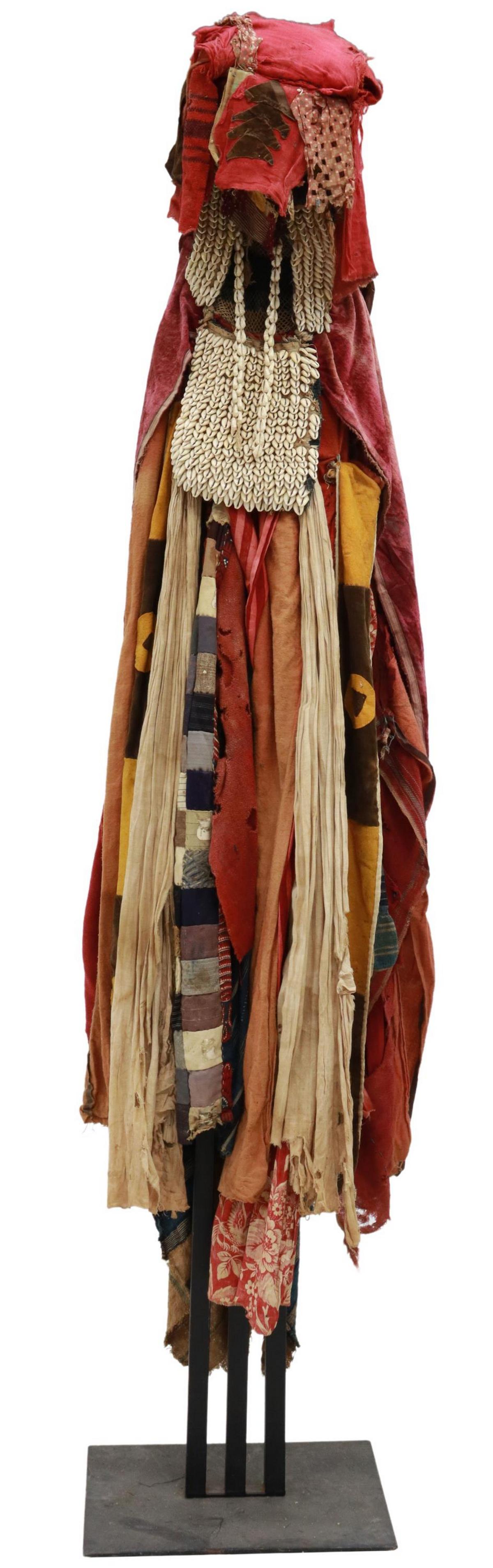 AFRICAN YORUBA PEOPLES OYA COSTUME ON STAND: African textiles, sewn together and affixed to a stand, representing an Oya costume, Yoruba peoples, in the form of a female deity, fashioned with various textiles, cowrie shell bag and headdress, ris