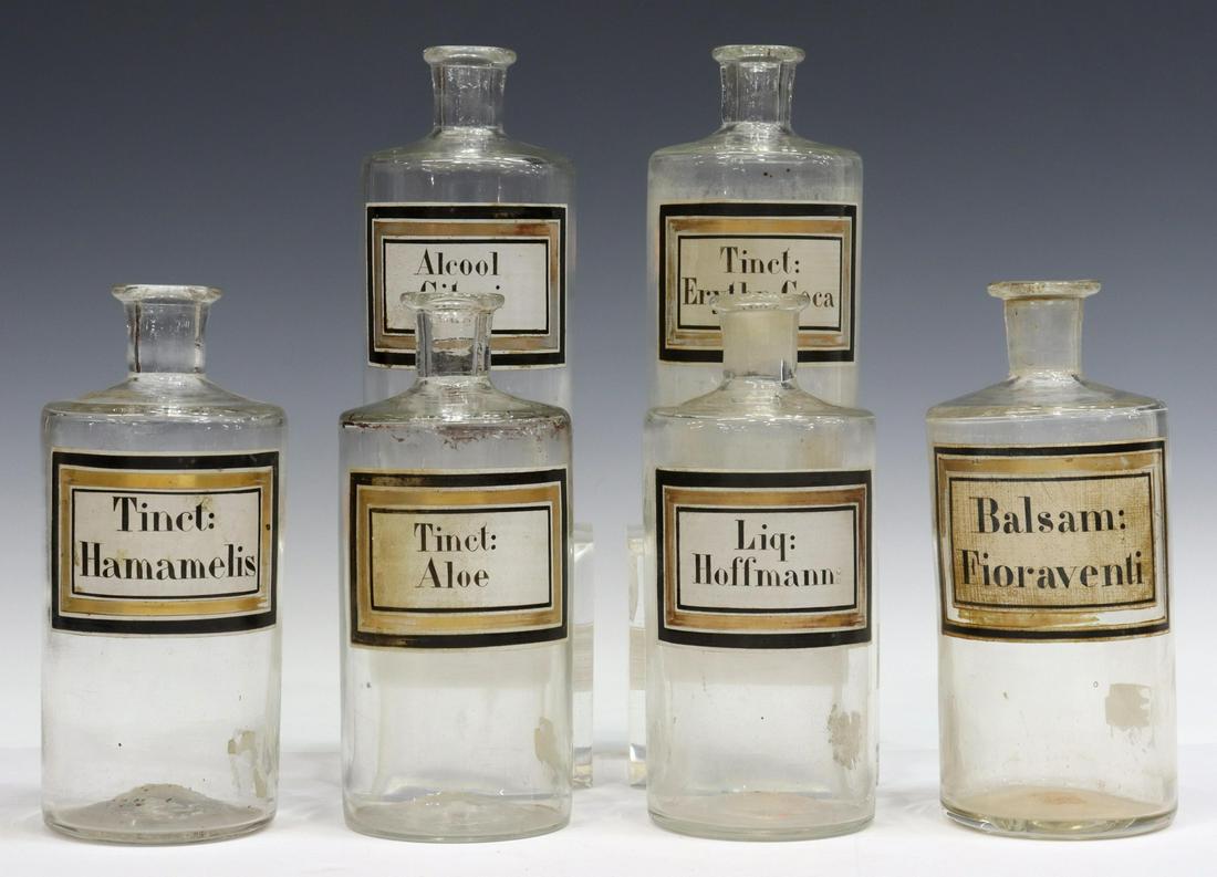 (6) ANTIQUE GLASS PHARMACEUTICAL APOTHECARY JARS: (lot of 6) Antique glass pharmaceutical apothecary bottles, late 19th/ early 20th c., parcel gilt labels, all lacking stoppers, approx 7.25"h, 3"diam; 5.5lbs total Start Price: $100.00
