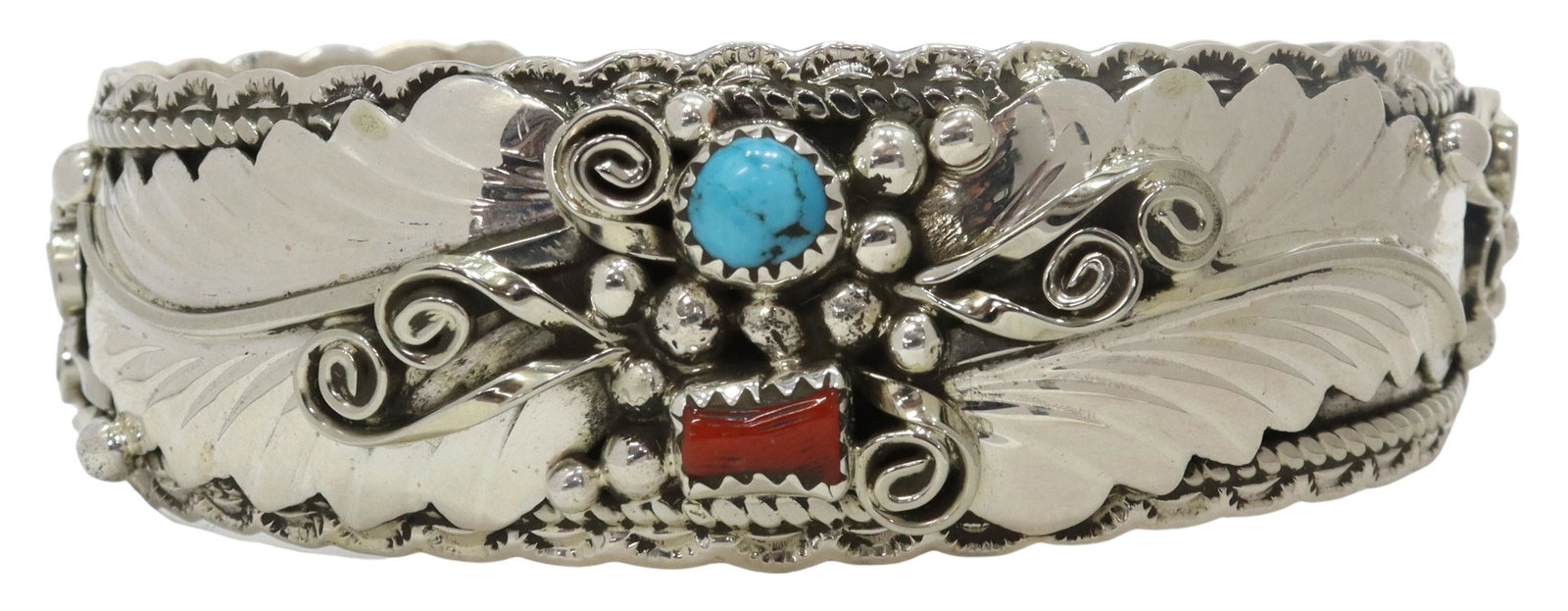 NATIVE AMERICAN STERLING, CORAL & TURQUOISE CUFF: Native American sterling silver cuff bracelet, signed GE (possibly Gary Edwards, Navajo, 20thc.), scalloped cuff with beaded and foliate design, bezel set red coral and small turquoise stone at center