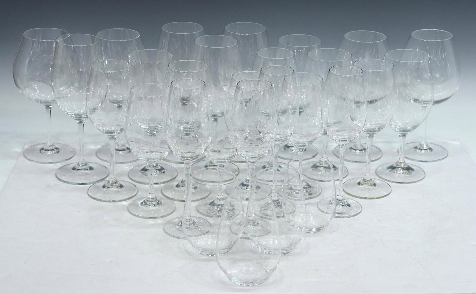 (28) RIEDEL COLORLESS GLASS WINE STEMS & TUMBLERS: (lot of 28) Riedel colorless stemware, all having acid-etched mark underfoot, comprising: (4) Cabernet/ Bordeaux stems, approx 8"h, 2.75"diam; $) Cabernet/ Merlot/ Syrah stems, approx 8 7/8"h, 2.75"di