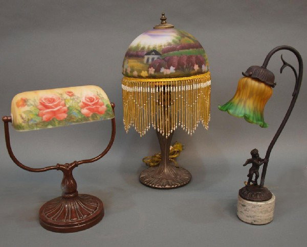 (3) DECORATIVE REVERSE PAINTED & METAL TABLE LAMPS: (lot of 3) Decorative table lamps: (1) having a reverse painted domical shade trimmed with beadwork, patinated metal base, 20"h; (1) desk lamp with revolving reverse decorated shade, 13'h; (1) metal a