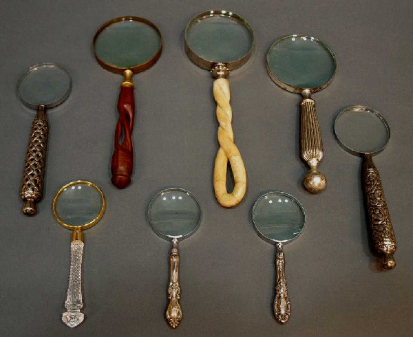 COLLECTION STERLING, WOOD, BONE MAGNIFYING GLASSES: (lot of 8) Magnifying glasses of varied size and design including (2) by Towle in sterling, (3) other silver tone examples, (1) likely bone, (1) carved wood example, (1) glass example, largest: 12.5"h