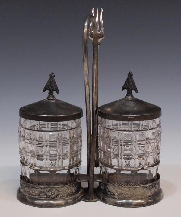 AMERICAN VICTORIAN DOUBLE PICKLE CASTOR: American double pickle castor, two pressed glass jars in a stylized pattern held in silver plated stand with associated lid and fork, floral motif to frame, fork marked 'Community Silver' with monogra