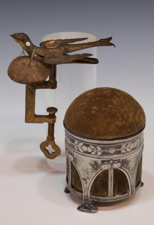 VICTORIAN SEWING BIRD & WMF SILVER PIN CUSHION: (lot of 2) Sewing accessories including: (1) Victorian brass sewing bird retaining screw clamp and worn pin cushion, dated on wing 1856?, 5.25"h; (1) pin cushion held by a WMF silver plated pewter Art
