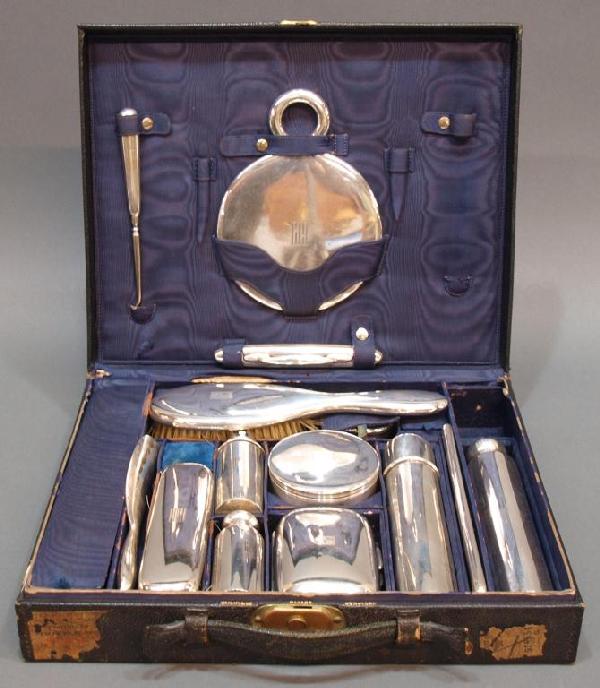 TIFFANY & CO STERLING SILVER TRAVELING DRESSER SET: (set of 15) Tiffany & Company leather traveling case, partially fitted with a fifteen piece sterling silver dresser set, marks indicate 1907 ~ 1947 (directorship of John C. Moore II), simple design wi