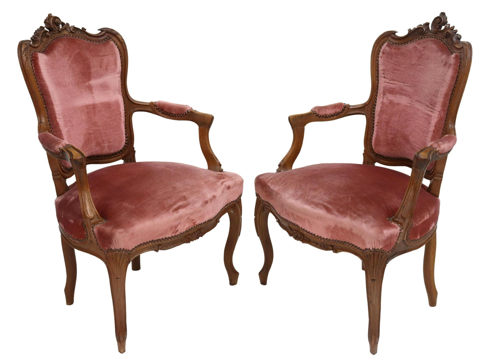(2) FRENCH LOUIS XV STYLE CARVED WALNUT FAUTEUILS: (pair) French Louis XV style walnut armchairs, late 19th c., carved rocaille crest, padded back, arms, and seat in pink mohair upholstery, with tack trim, rising on cabriole legs, restoration at arms,