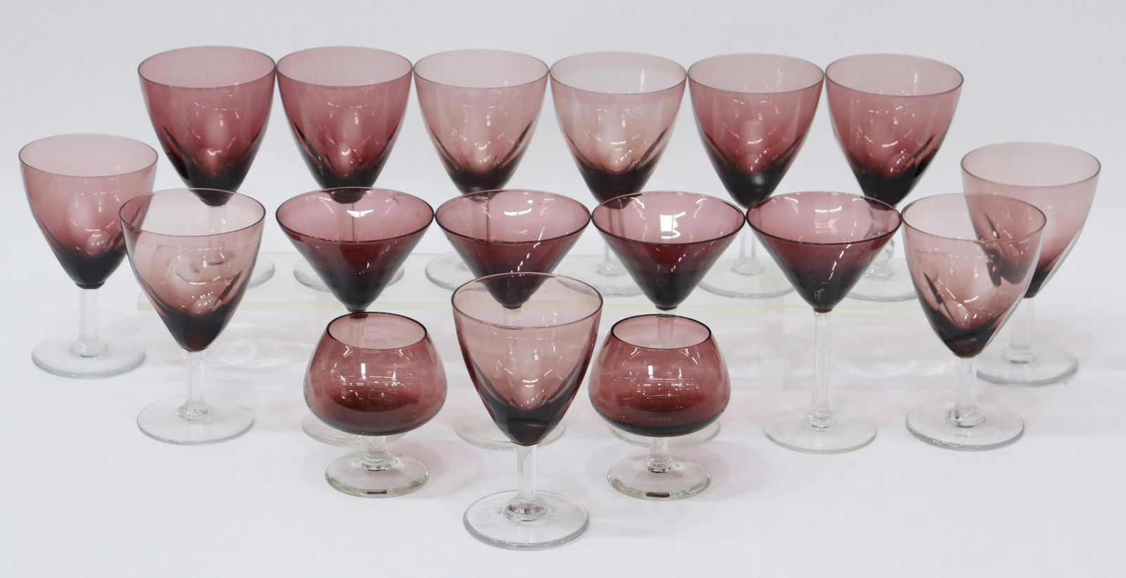(17) PURPLE COLORED CUT CRYSTAL GLASSWARE, 20THC.: (lot of 17) Collection of purple colored glassware, 20thc., some cut, including: (2) brandy snifters, approx 3.25"h, 3.5" diam; (11) wine glasses, one with shaped stem, some with imperfections, approx