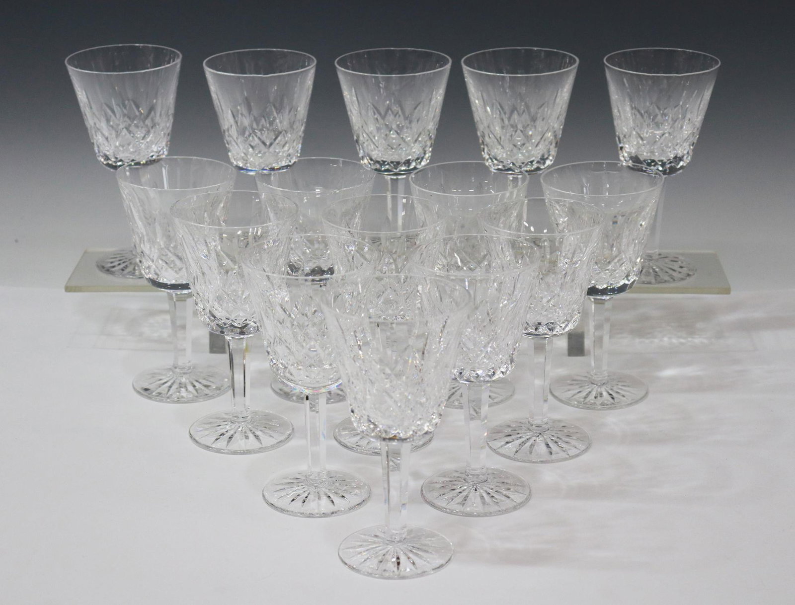 (15) WATERFORD LISMORE CUT CRYSTAL CLARET GLASSES: (lot of 15) Waterford "Lismore" cut crystal claret wine glasses, acid-etched mark underfoot, one with small chip to pattern, one with small chip to rim, some variations in foot pattern, approx 5 7/8"h