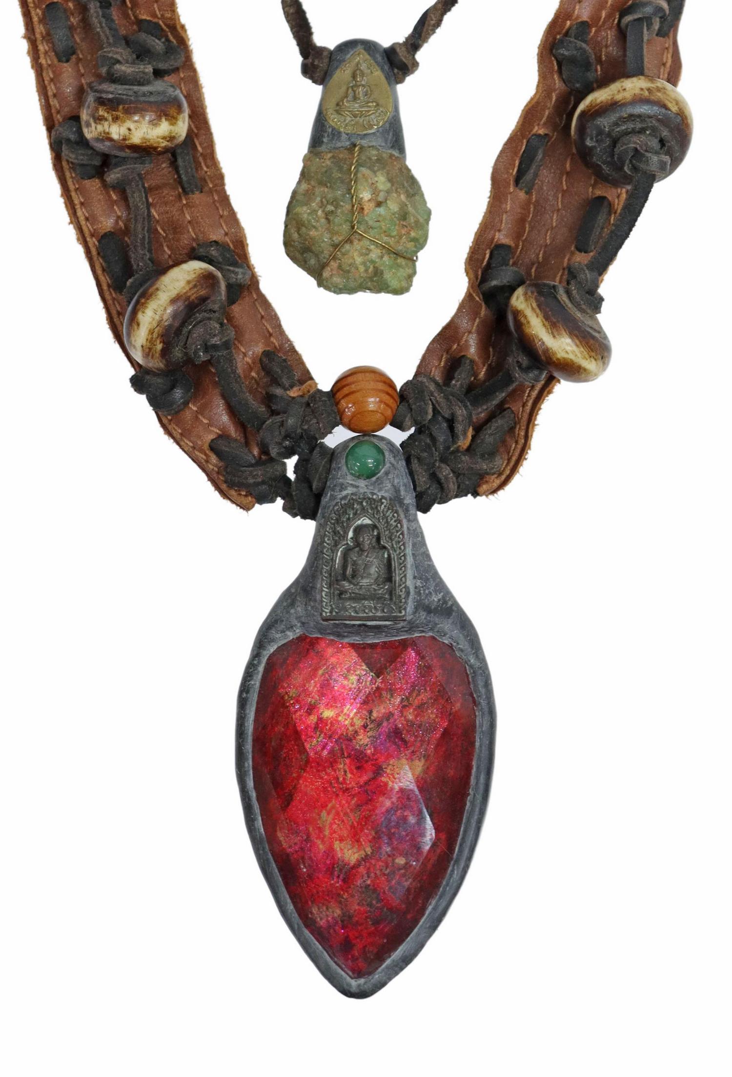 ANOTHAI HANSEN STATEMENT NECKLACE, CRYSTAL & GEM: Artisan one-of-a-kind wearable art statement necklace, Anothai Hansen (Thailand/ New York, 20th c.), raw emerald and faceted pendant, surmounted by the Buddha and seated monk amulets respectively, thi