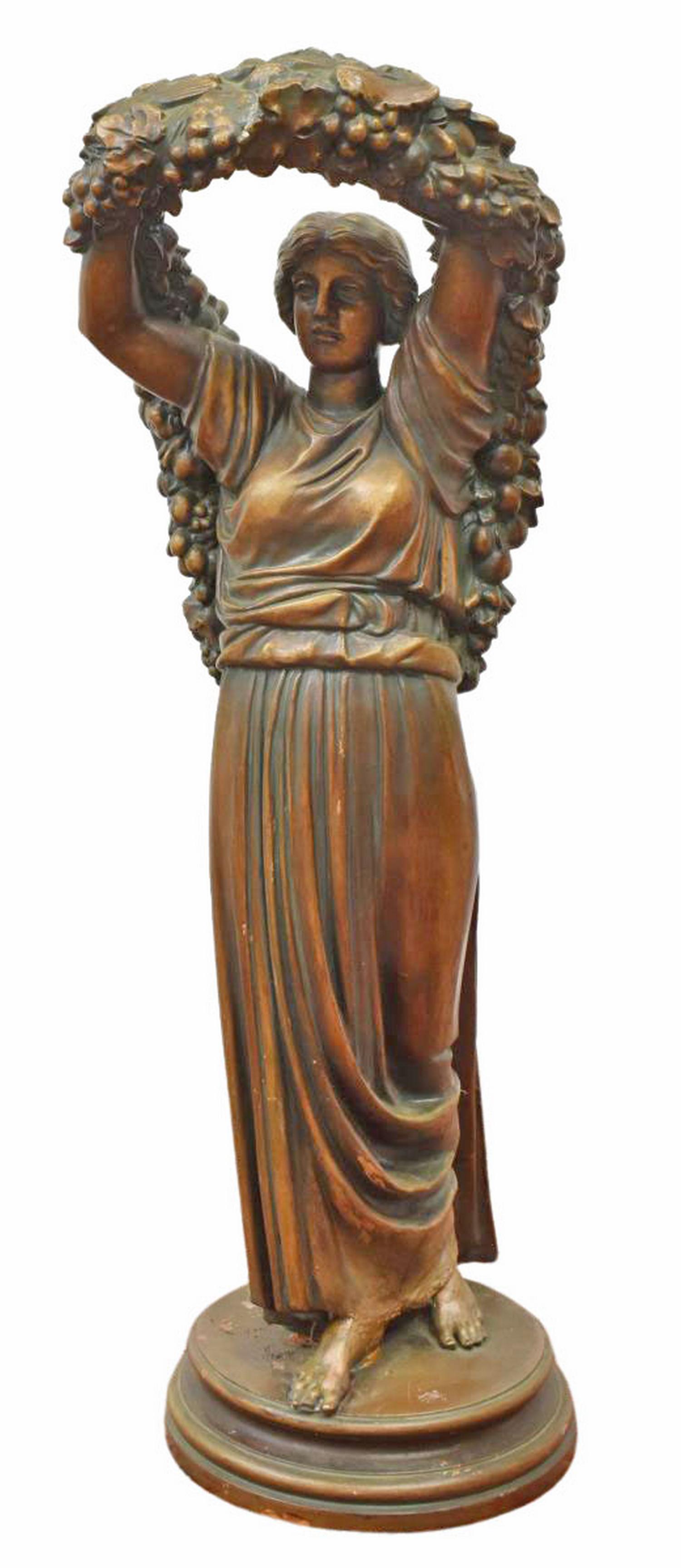 ART NOUVEAU TERRACOTTA FIGURAL SCULPTURE: Art Nouveau terracotta sculpture, early 20th c., woman in draped gown, holding aloft a garland with fruit and foliates, standing on a circular base, intact with total restoration to lower figure, chip