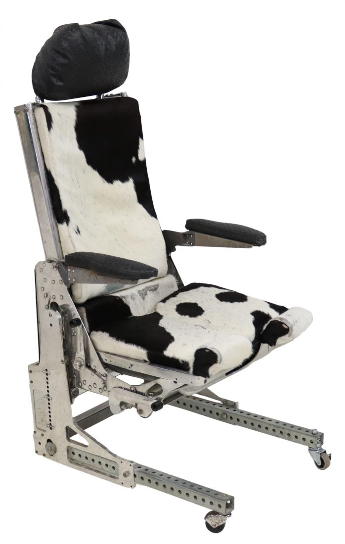 AEROTHERM AIRPLANE CHAIR IN COWHIDE: Aerotherm Corp., Bantam, Ct. airplane seat, Model 404A, now with black and white cowhide upholstery, removable seat cushion, exposed steel and aluminum frame, padded arms rest, adjustable and raised o