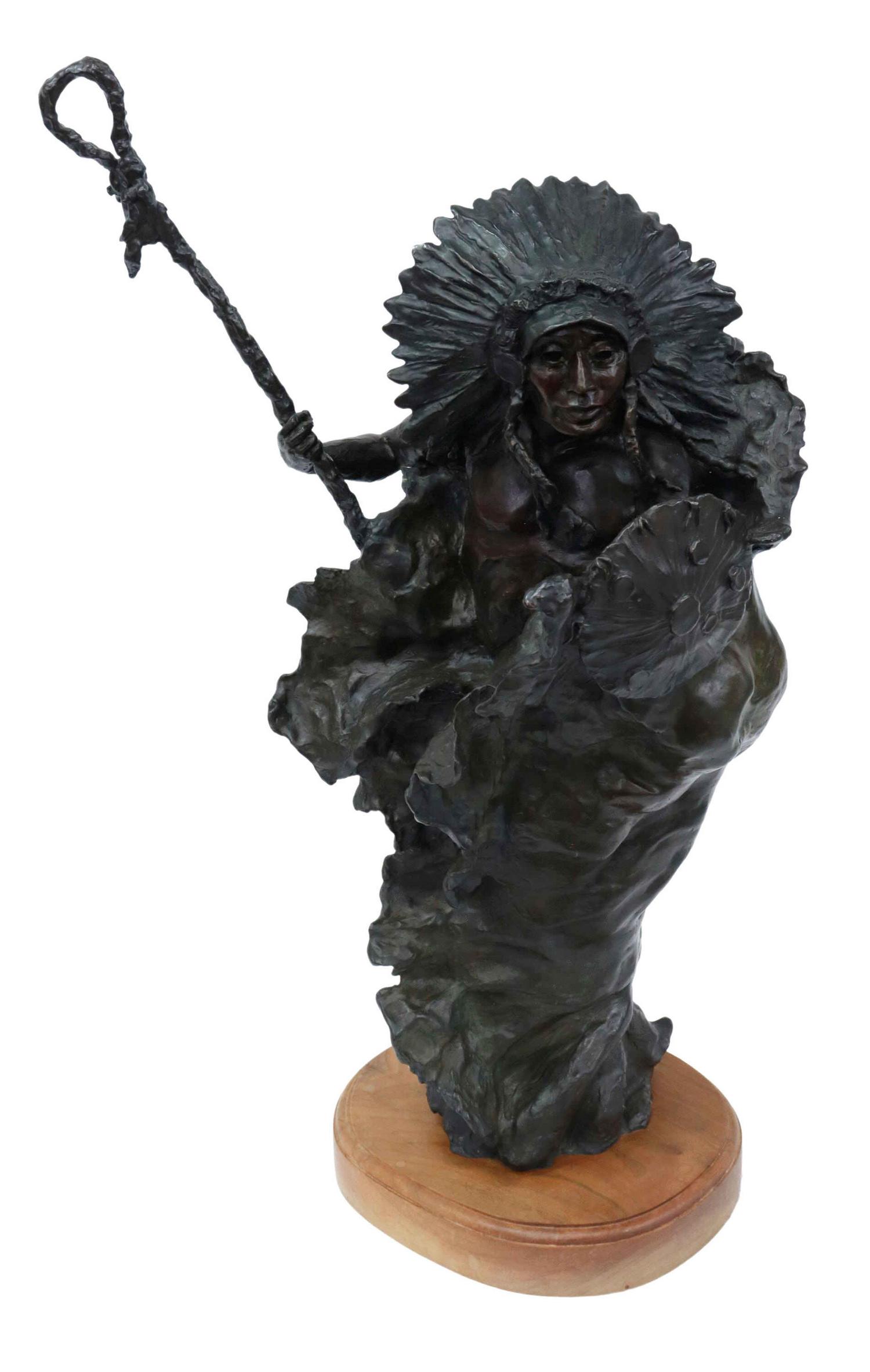 NANCY McLAUGHLIN (D.1985) NATIVE AMERICAN BRONZE: Western patinated bronze sculpture, The Sun, signed at base McLaughlin (Nancy Powell McLaughlin, Montana, 1932-1985), dated 1977, numbered 10/ 10, Native American man with shield and staff, on wood pl