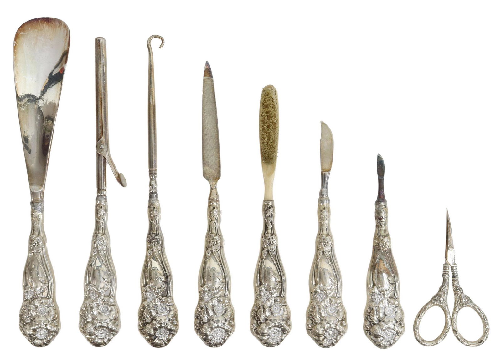 (8) AMERICAN STERLING-HANDLED DRESSING SET: (lot of 8) American sterling-handled dressing set, hollow handles with repousse poppies, including: (1) button hook, (1) hair curling iron, (1) cuticle knife, (1) file, (1) small nail scissors, (1) br