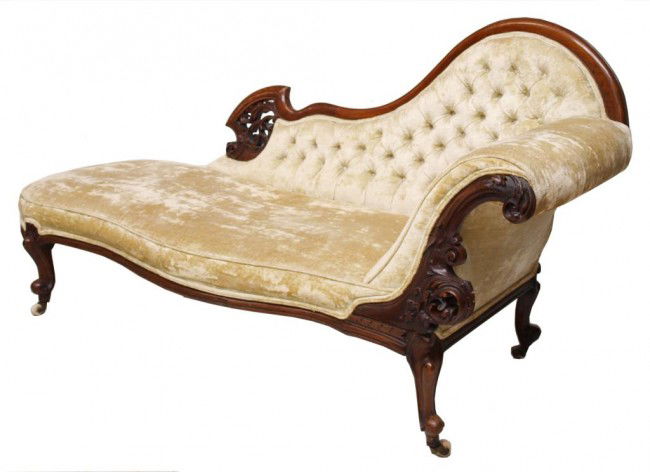 AMERICAN VICTORIAN PIERCE CARVED WALNUT SOFA: American Victorian carved walnut fainting couch, late 19th c., upholstered cushion and rolled arm joined to tufted back, cabriolle legs rise on castors, rear frame with stamp from The British Antique