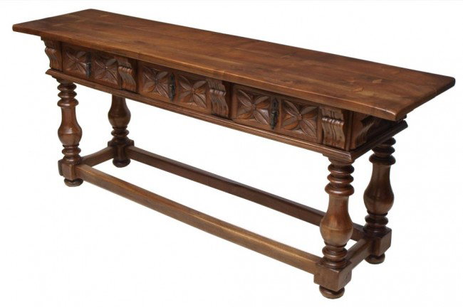 ANTIQUE SPANISH BAROQUE STYLE CARVED CONSOLE TABLE: Spanish Baroque style carved walnut console, 20th c., the thick top fashioned from three boards with six diamond form inlays, three foliate carved drawers separated by scrolled corbels rising on ring 