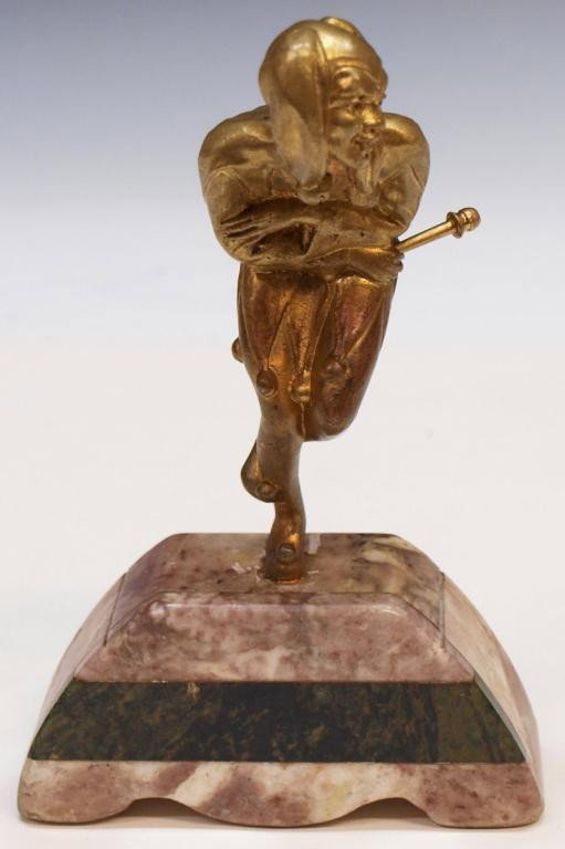 ART DECO GILT METAL FIGURE OF A HARLEQUIN: Art Deco gilt metal jester statue on a marble stand, jester bent over, scepter in one hand, 7"h, 1.75lbs total Start Price: $50.00