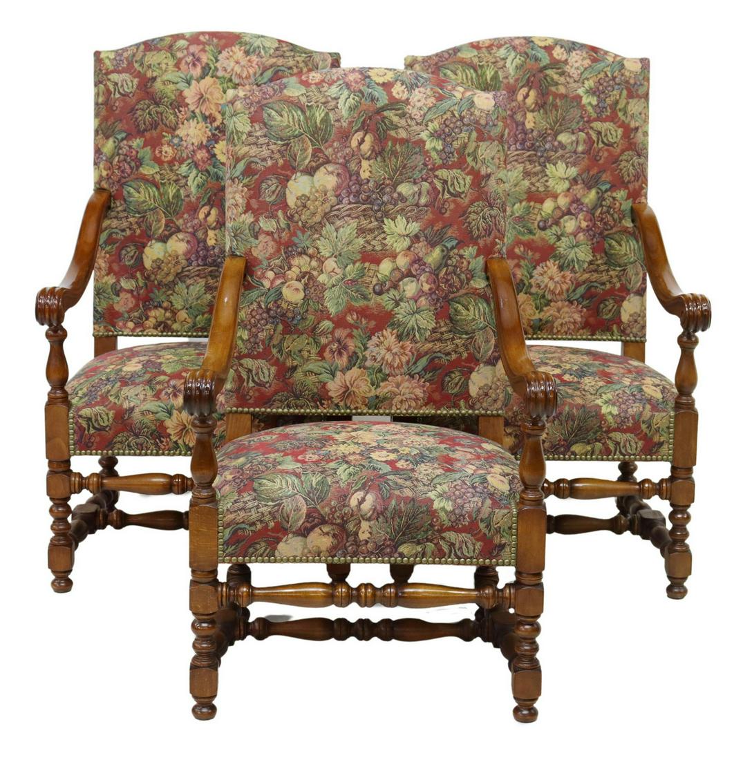 (3) FRENCH LOUIS XIII STYLE UPHOLSTERED FAUTEUILS: French Louis XIII style armchairs, 20th c., having shaped back, in fruit and foliate woven upholstery, with nailhead trim, scrolled handholds, rising on turned stretcher-joined legs, approx 41"h, 24"w