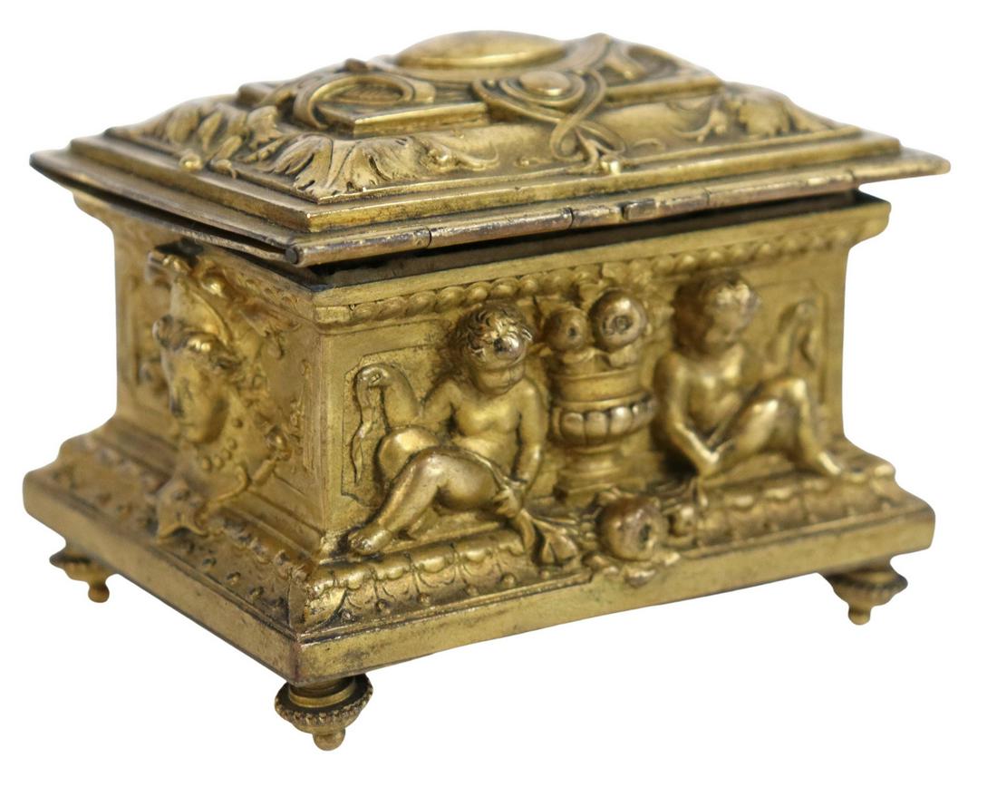 PETITE FRENCH NEOCLASSICAL GILT METAL JEWEL CASKET: French Neoclassical gilt metal jewel casket, 19th c., with cherubs and foliate accents in relief, worn silk-lined interior, rising on toupie feet, approx 2.5"h, 3 1/8"w, 2.25"d, 0.5lbs Start Price: $2