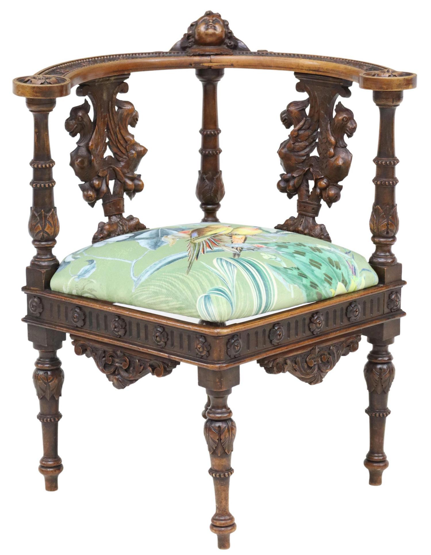 FRENCH RENAISSANCE REVIVAL WALNUT CORNER CHAIR: French Renaissance Revival walnut corner chair, late 19th/ early 20th c., rounded back, centering protruding cherub mask crest, carved splats with opposing griffins, over tropical upholstered seat, ri