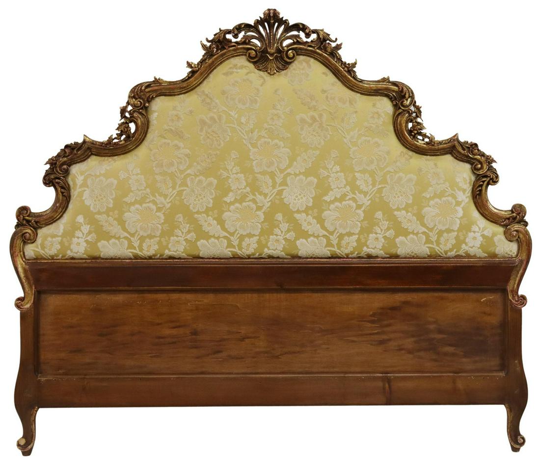 VENETIAN PARCEL GILT DAMASK UPHOLSTERED HEADBOARD: Venetian parcel gilt headboard, 20th c., parcel giltwood carved foliate crest and shaped frame, over yellow damask upholstered backboard, rising on cabriole legs, ending in whorl feet, some loss throu