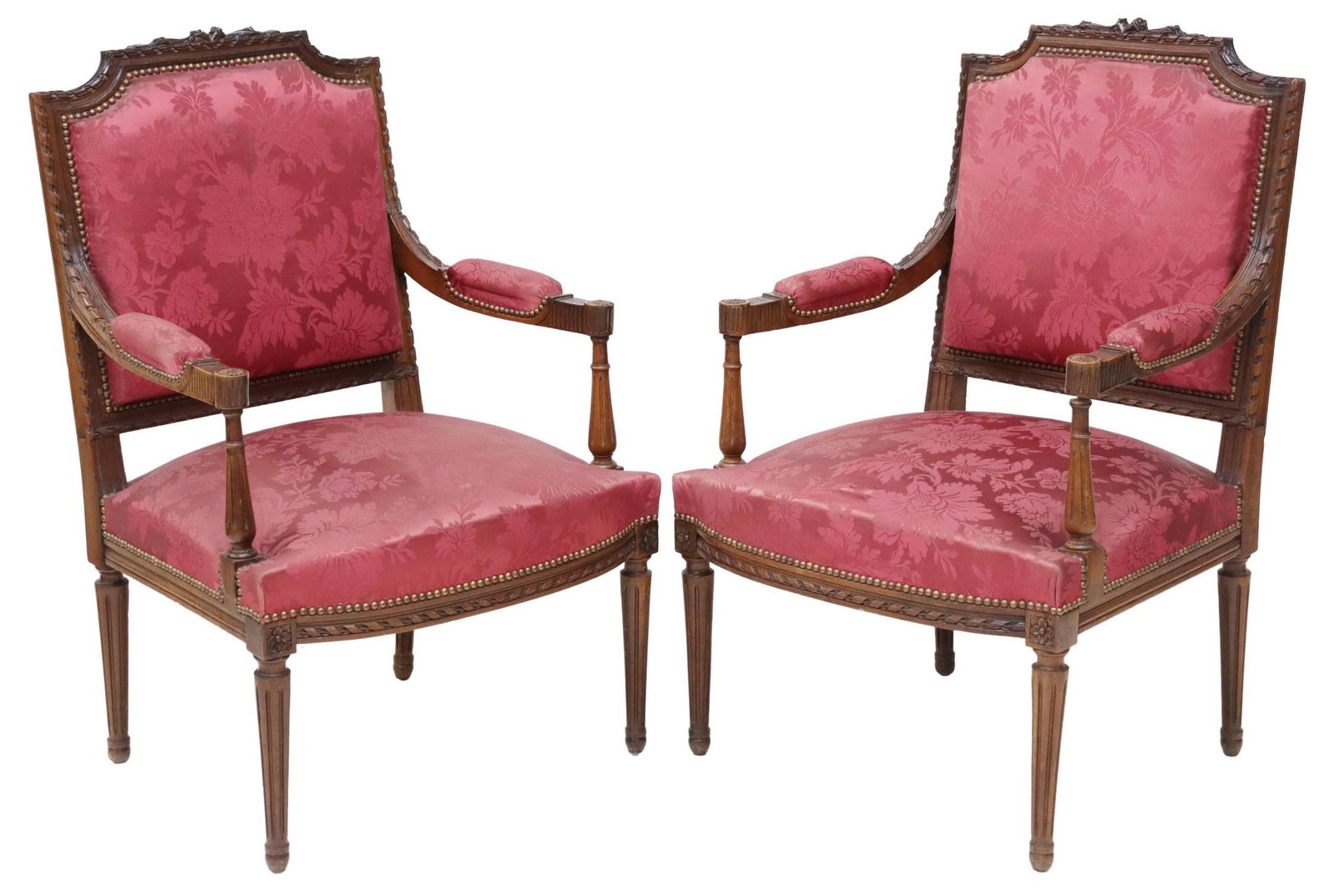 (2) FRENCH LOUIS XVI STYLE DAMASK FAUTEUILS: (pair) French Louis XVI style armchairs, 19th c., carved floral crest, surrounded by carved ribbon frame in a mahogany finish, back, seat and arms upholstered in a red damask, with nailhead trim, risi