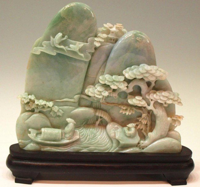CHINESE CARVED JADEITE MOUNTAINOUS TABLE SCREEN: Chinese carved jadeite mountain, the mottled green stone carved as a range of mountains and a pagoda, pine trees and cranes above figures below, 9"h, 9.5"w, 8.75lbs Start Price: $800.00