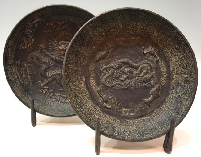 SOUTHEAST ASIAN BRONZE DRAGON CHARGERS: (lot of 2) Southeast Asian bronze chargers of circular form, each centering a dragon, 12" diam, 10.25lbs total Start Price: $150.00