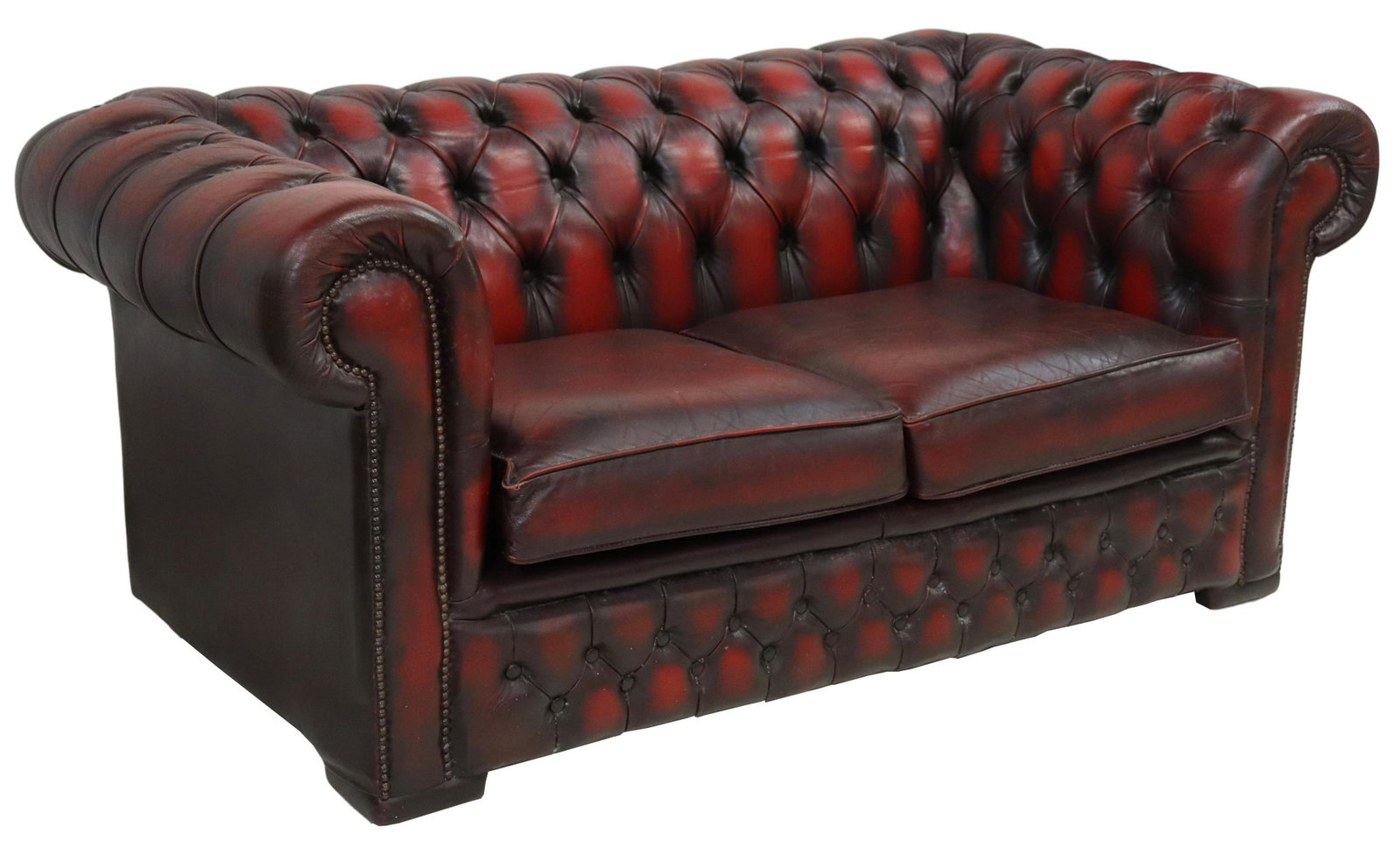 ENGLISH OXBLOOD LEATHER CHESTERFIELD TWO-SEAT SOFA: English Chesterfield oxblood leather loveseat/sofa, 20th c., having oxblood leather upholstery, button-tufted rolled back and arms, brass tack trim, two loose seat cushions, rising on casters, approx 