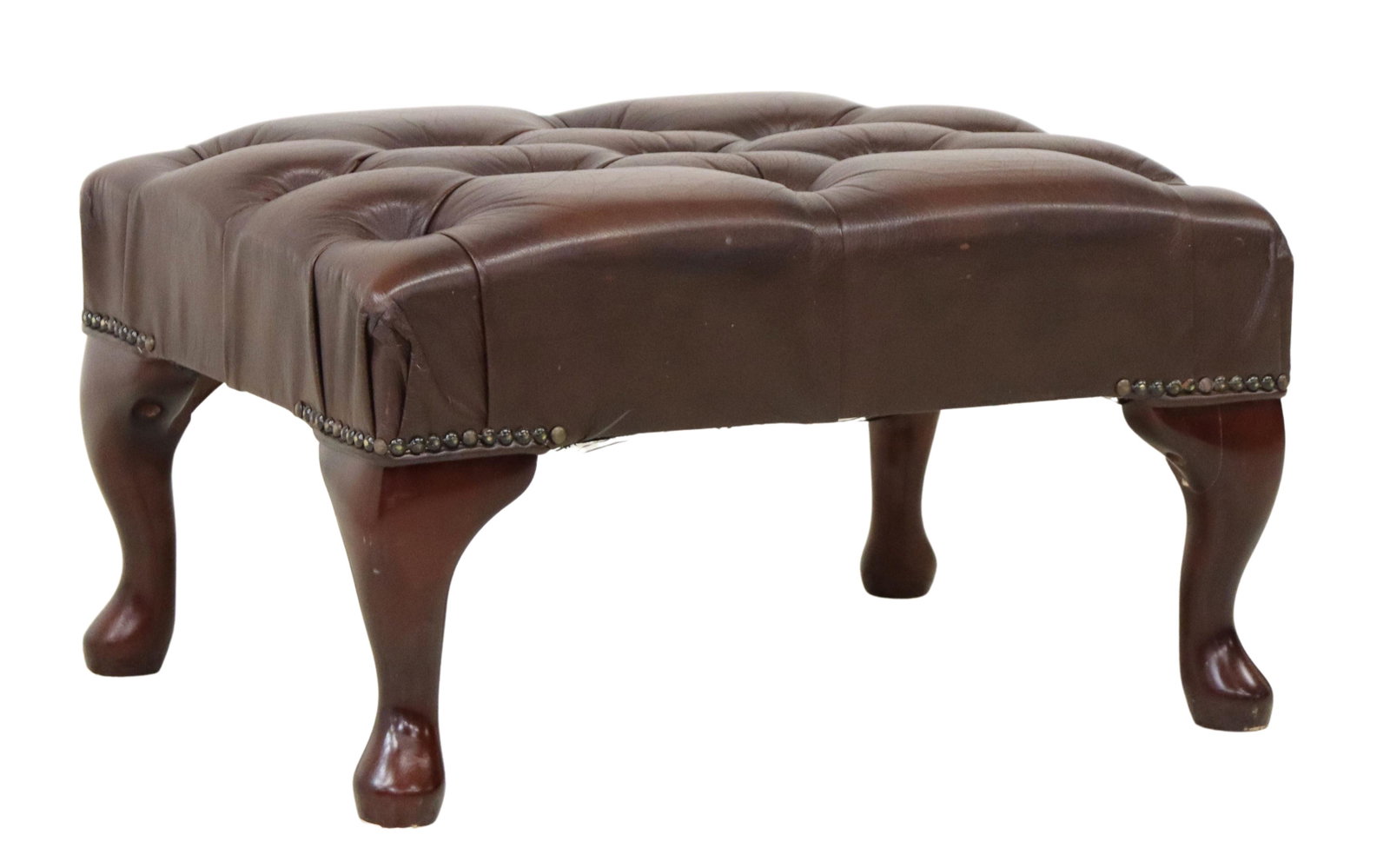 ENGLISH QUEEN ANNE STYLE LEATHER FOOTSTOOL: English Queen Anne style leather footstool/ ottoman, 20th c., brown button-tufted leather, with nailhead trim, rising on cabriole legs, ending in pad feet, approx 12"h, 22.25"w, 16.5"d Start Price: $1