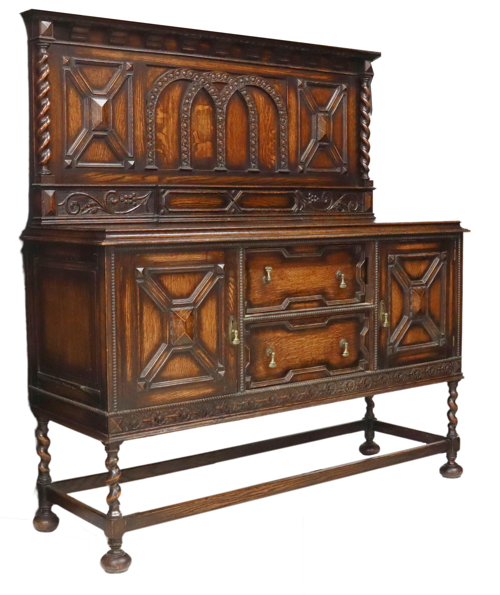 ENGLISH JACOBEAN STYLE OAK BARLEY TWIST SIDEBOARD: English Jacobean style oak sideboard, 20th c., backsplash with carved geometric and arcaded panels, over floral accents, case fitted with two central drawers, flanked by side cabinets, rising on barle