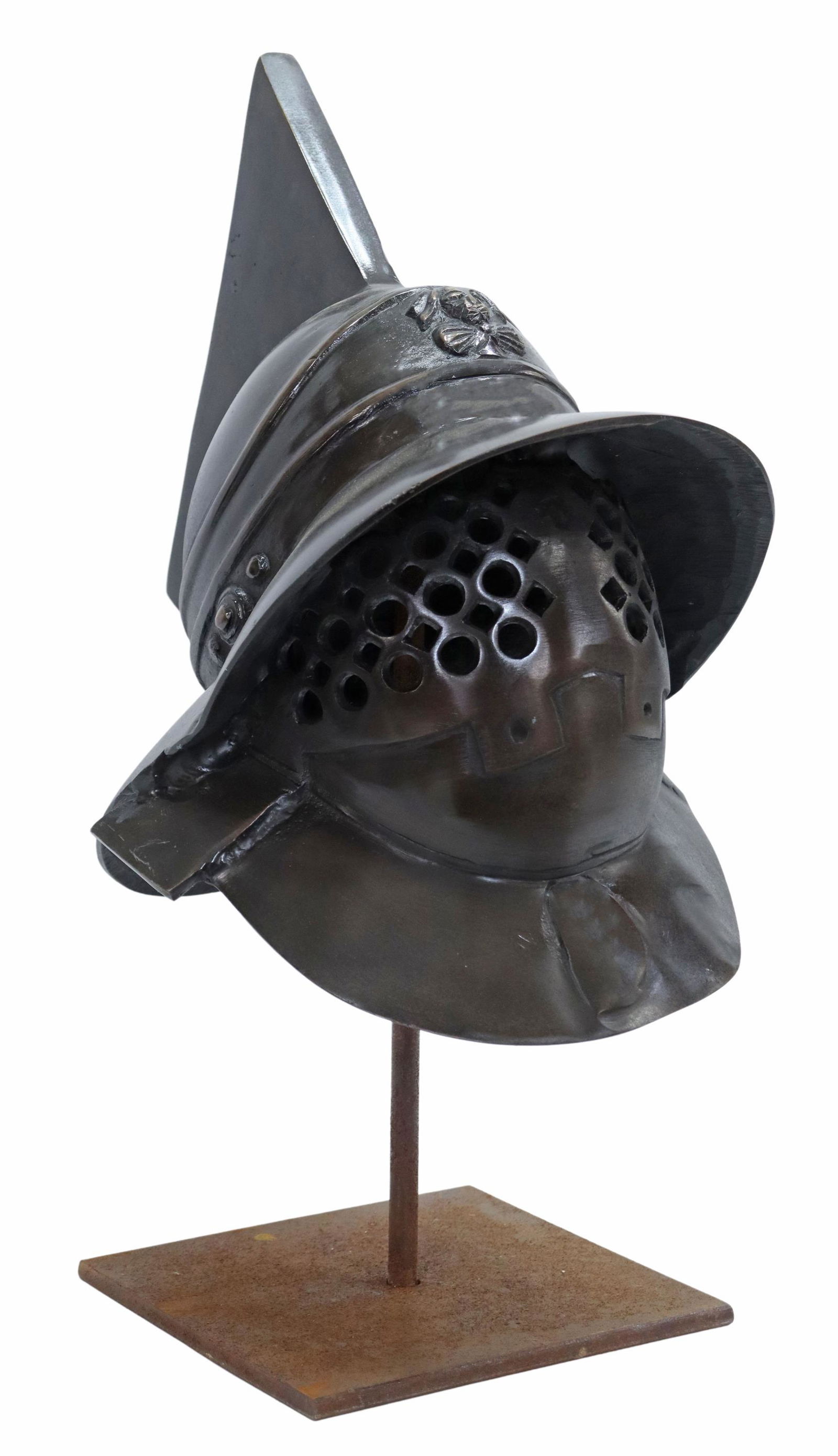 PATINATED METAL GLADIATOR STYLE HELMET ON STAND: Decorative patinated metal helmet on iron display stand, 20th c., Murmillo gladiator style, having unadorned crest over sloped visor, figural adornment at front face, perforated eye openings, approx 2