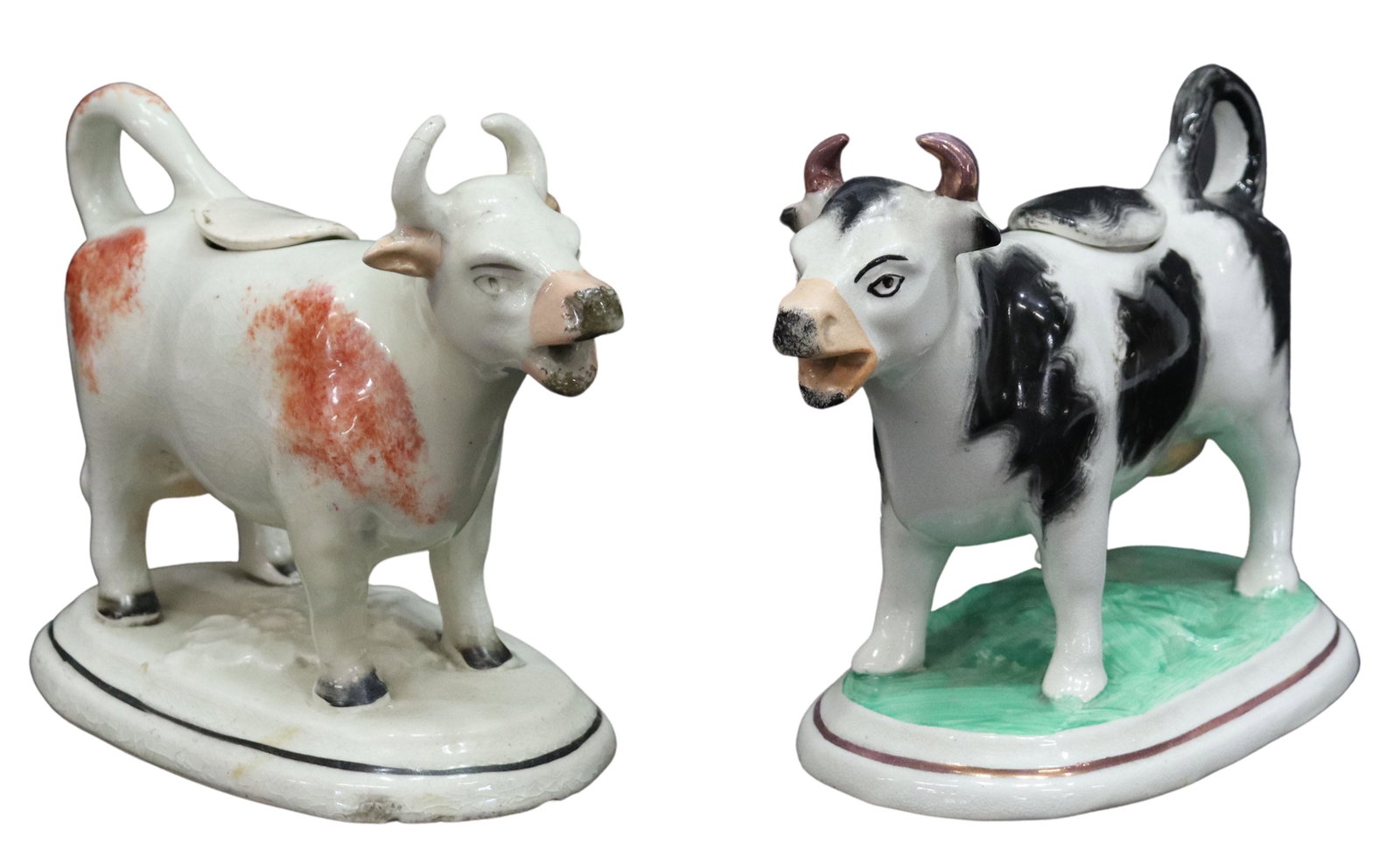 (2) ENGLISH VICTORIAN STAFFORDSHIRE COW CREAMERS: (lot of 2) English Victorian Staffordshire cow creamers, 19th c., including: (1) painted in black with lustre accents, approx 5"h, 6.25"w, 2.5"d; (1) painted in brown with floral motif at base, restor