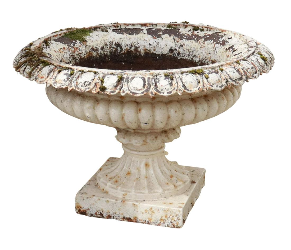 WHITE PAINTED CAST IRON GARDEN URN PLANTER: Cast iron garden urn planter, egg and dart rim, over melon ribbed body, rising on square base, remnants of white paint, approx 14.5"h, 22"diam Start Price: $300.00