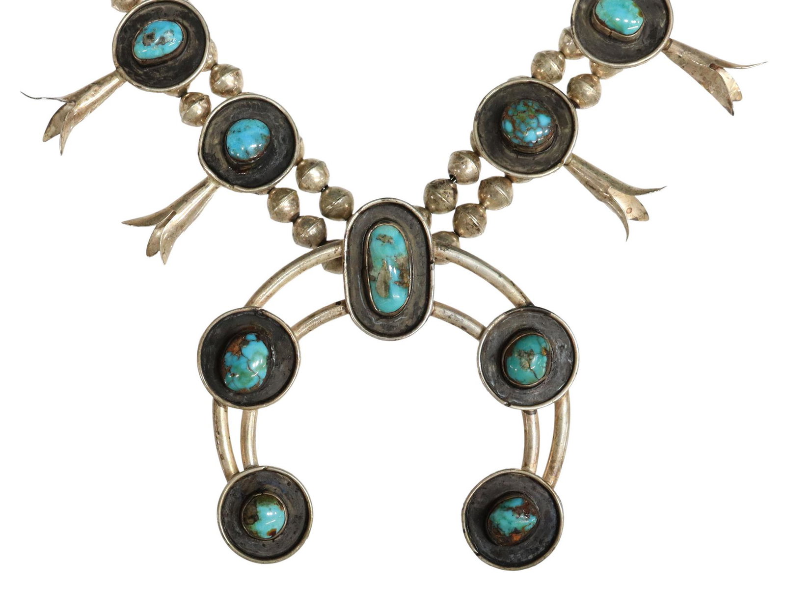 NATIVE AMERICAN TURQUOISE SQUASH BLOSSOM NECKLACE: Native American silver (content unknown) squash blossom necklace, twelve blossoms, each set with a turquoise cabochon, central naja pendant with five turquoise cabochons, double bench bead strands to 