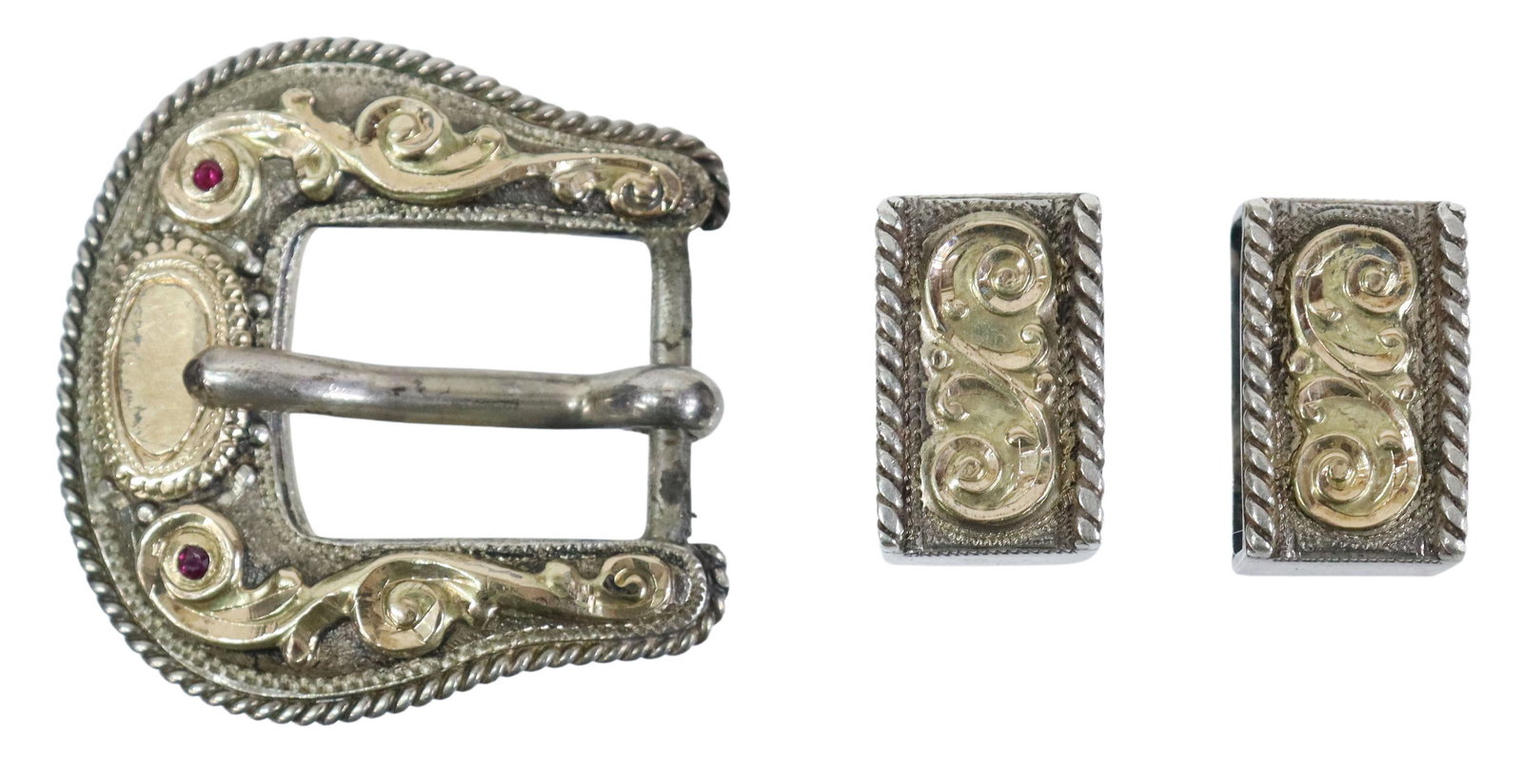 HOLLAND'S STERLING & 14KT GOLD 905 BUCKLE SET: (lot) Western sterling silver and 14kt yellow gold ranger belt buckle set, Holland's, San Angelo, rope twist edge, scrolls, red gemstones, accommodates a belt tapered to approx 0.5", including: (one) 